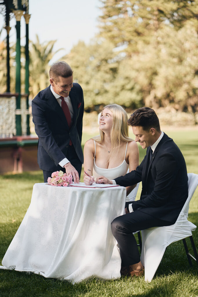 couple signing at wedding with celebrant